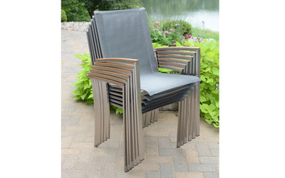 Stacked gray armchairs in front of greenery