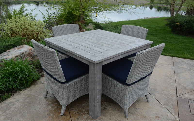 Weathered teak design set in front of a body of water and lawn