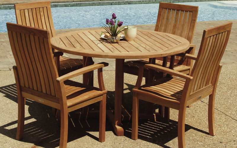 Teak dining set with round table and four chairs in front of pool