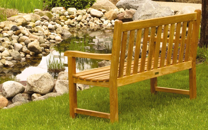 Back view of a teak bench by a pond