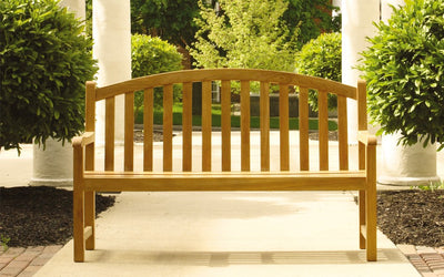 Classic teak garden bench  with lush landscape in the background