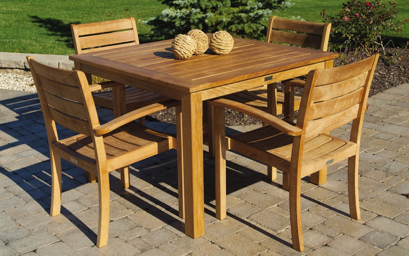 Teak dining set with square table and four chairs on paver patio