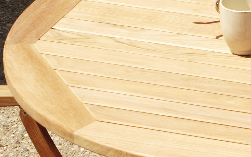 Close up of round teak dining table with cup on top