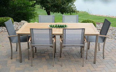 Rectangular wooden table with six gray armchairs on brick patio